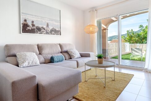 Salón con sofá cómodo y acceso a la terraza en una casa de El Casalot, mostrando una decoración luminosa y acogedora
