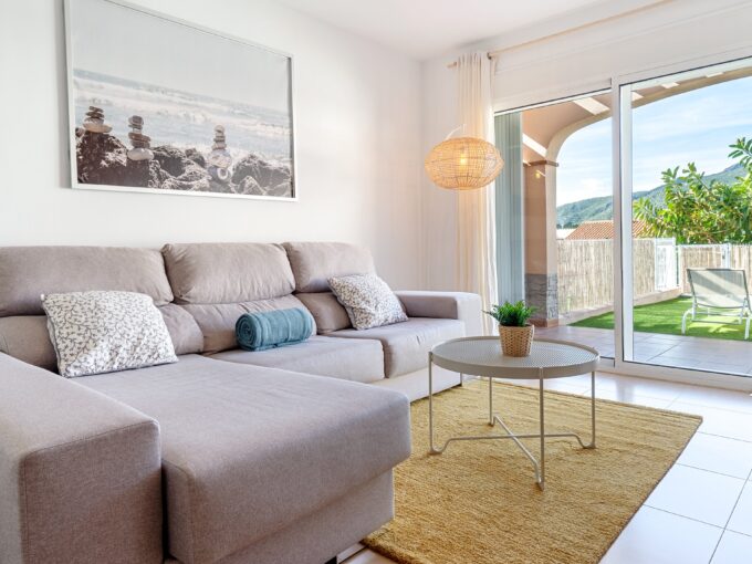 Salón con sofá cómodo y acceso a la terraza en una casa de El Casalot, mostrando una decoración luminosa y acogedora